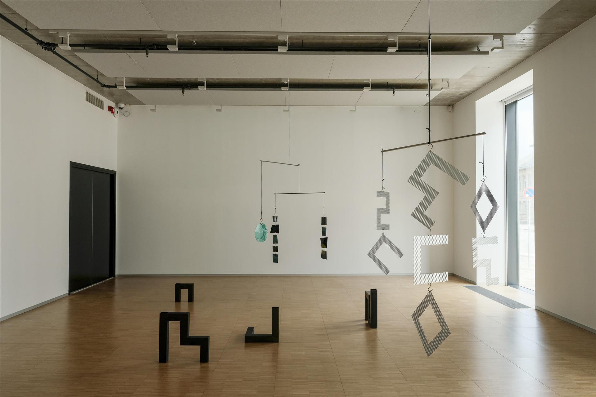Rom. Kunst som står på gulv og henger fra taket.